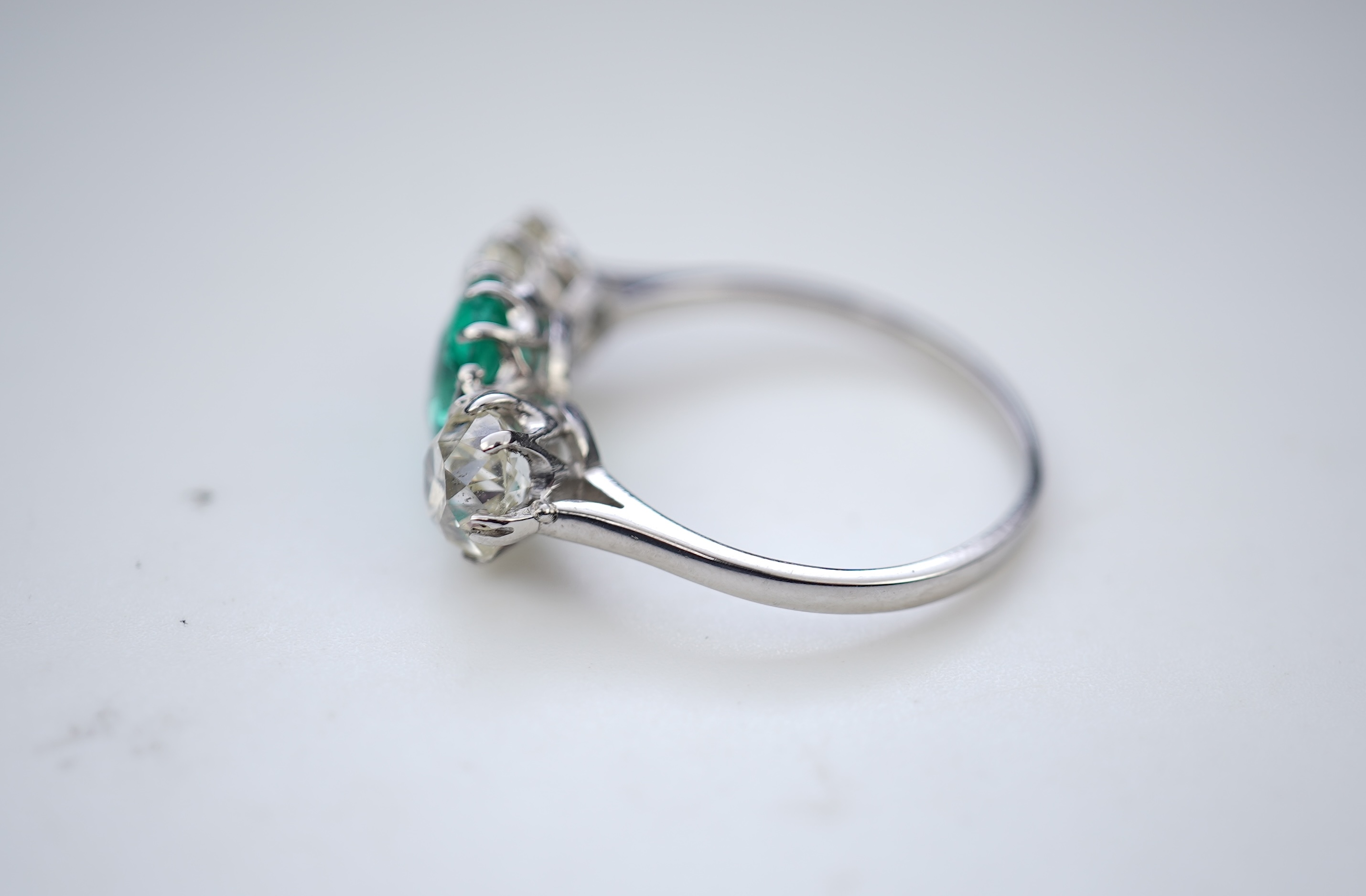 An attractive emerald and diamond three-stone ring, early 20th century